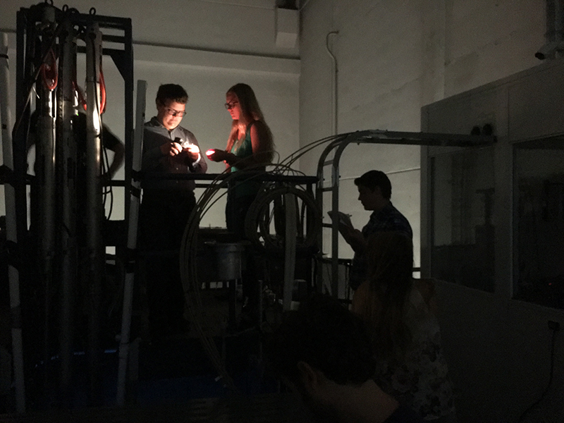 Students conduct probe reading in nuclear experiment at the PULSTAR reactor pool-top bridage